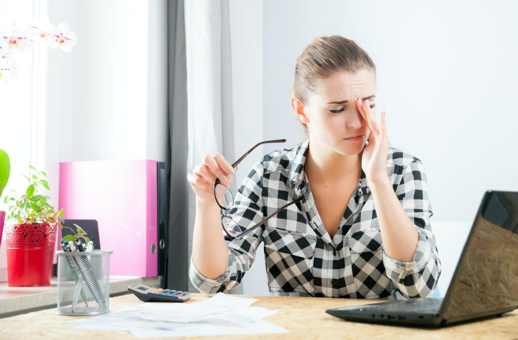Tired woman with eye pain during working in home office